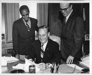 Two men observe Colorado Governor John A. Love signing bill later celebrated on Charter Day, May 1, 1970