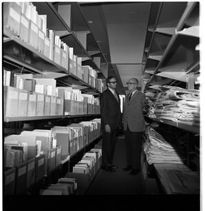 J. Gilbert Hause and James A. Michener standing among the serials collection, ca. 1972