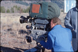 John Wilder looking through movie camera, Grand Teton National Park, Wyoming, 1977