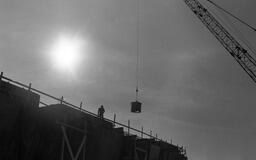 Worker stands atop University Library construction site, early 1970s