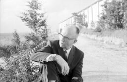 James A. Michener sitting on the ground