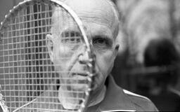 James A. Michener with tennis racket, 1975