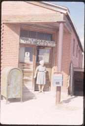 "Mrs. Oram" at the entrance to the post office in Keota, CO